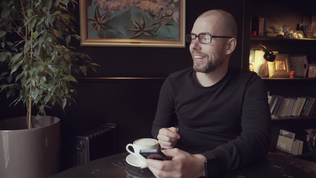 Uomo che usa uno smartphone in un bar