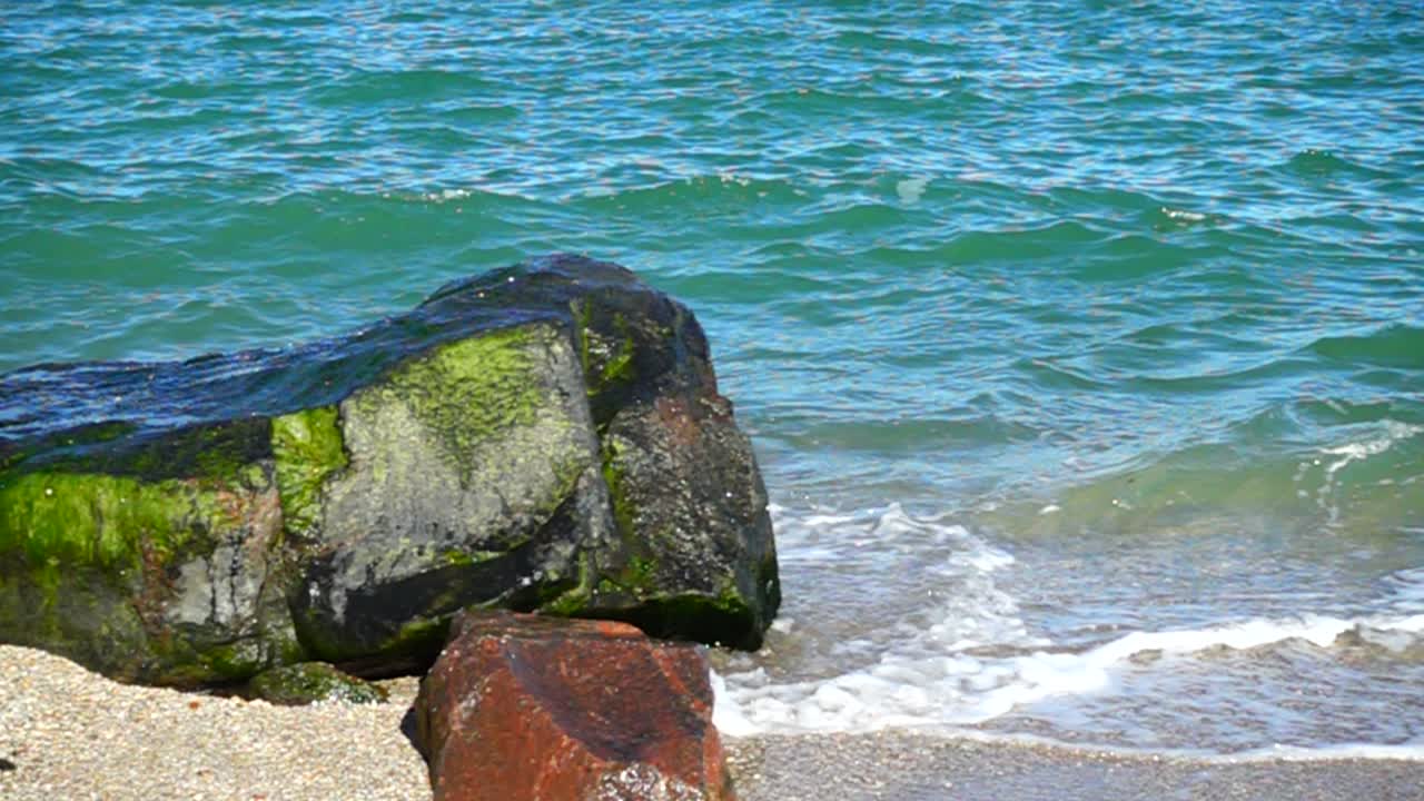 Onde del mare si infrangono contro le pietre. Riprese sulla costa. Slow motion