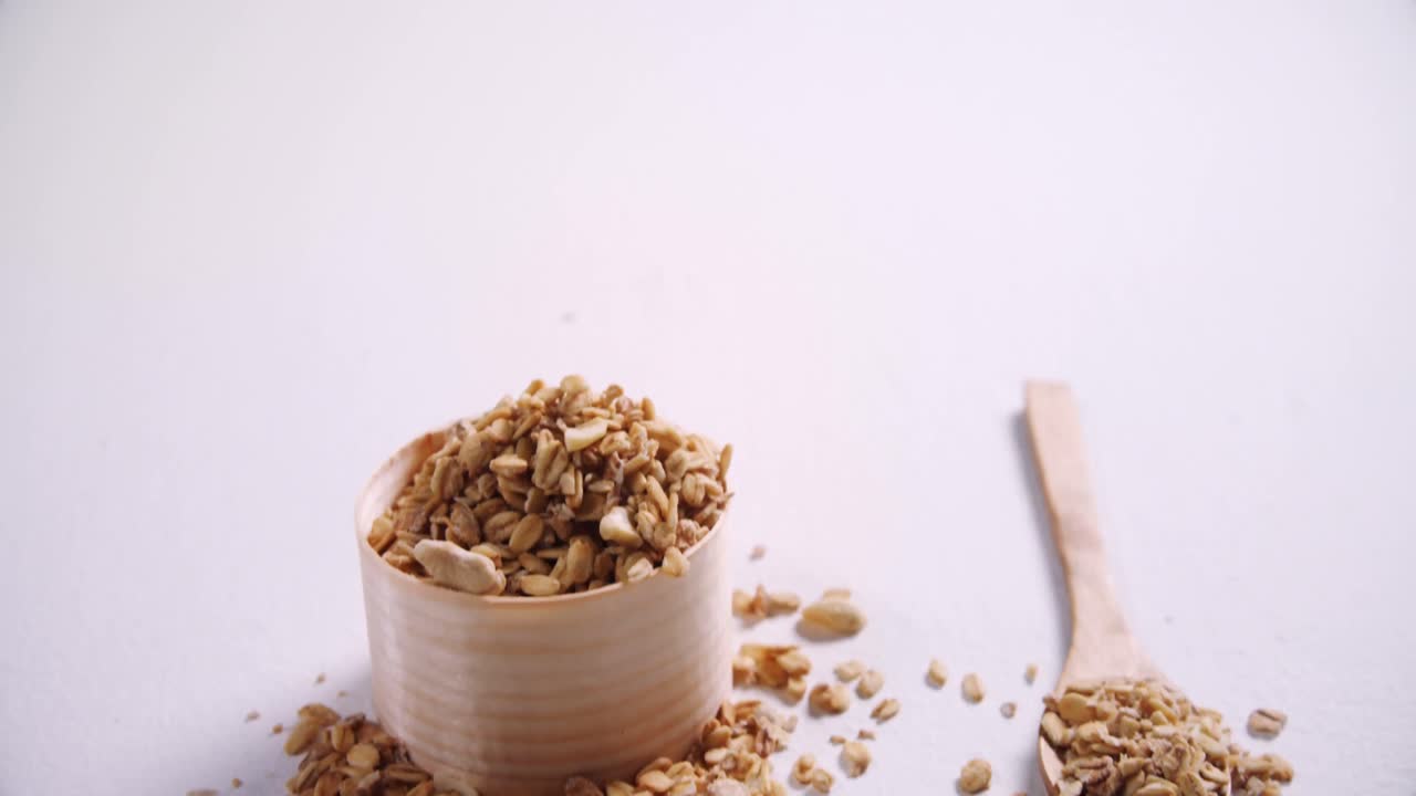 Oat flakes in a wooden bowl and spoon 4k