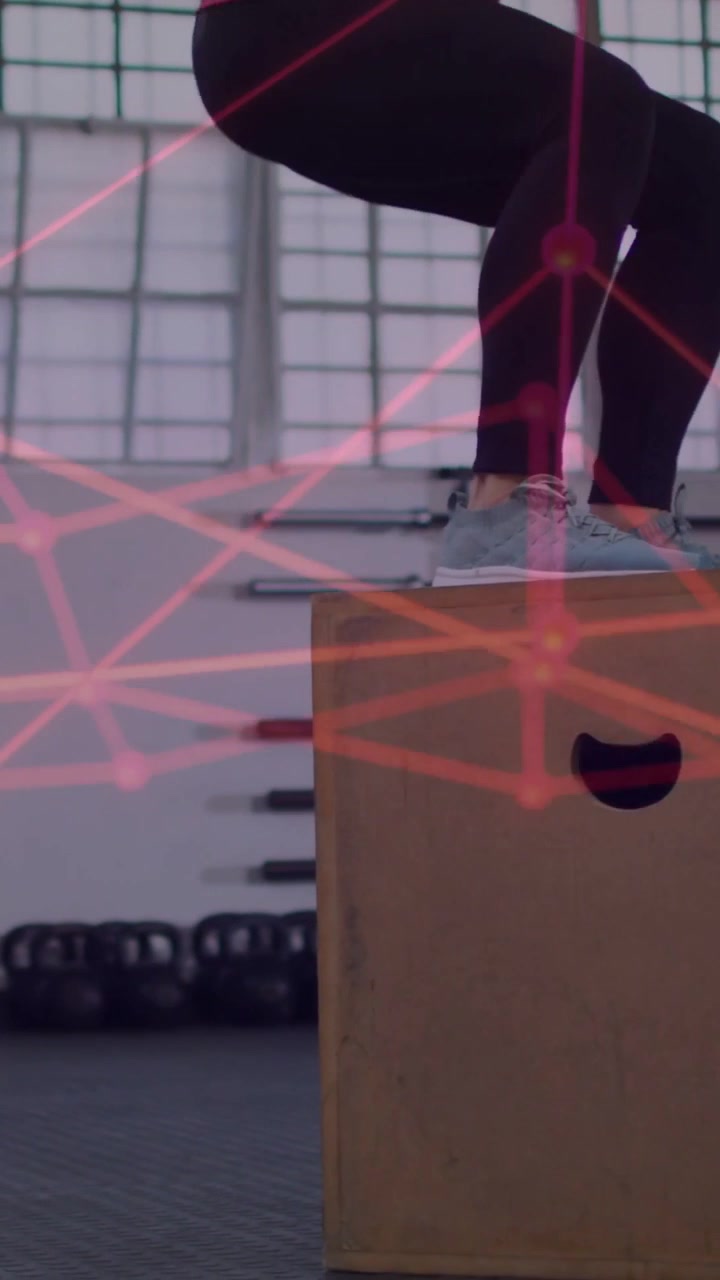 Woman nearing plyo box swinging arms, jumping onto box in gym training pink overlay tracking motion