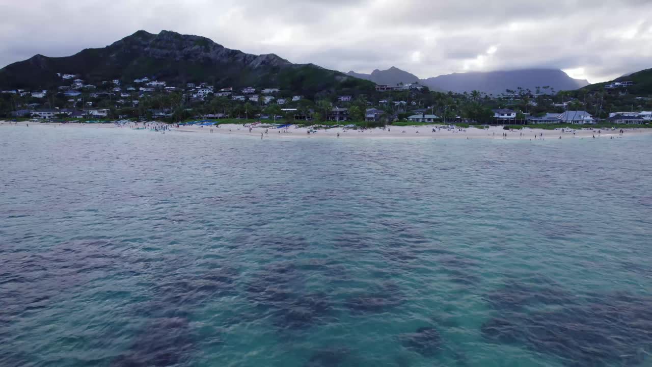 imágenes de drones de la playa de lanakai en la isla de oahu con montañas de la isla en el fondo con playas de arena blanca que bordean la costa en hawai