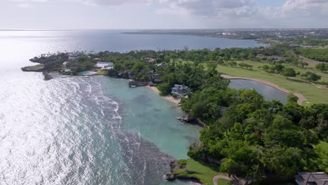 sobrevuelo aéreo casa de campo la romana con lago, piscina privada y playa de arena en verano - punta aguila, república dominicana