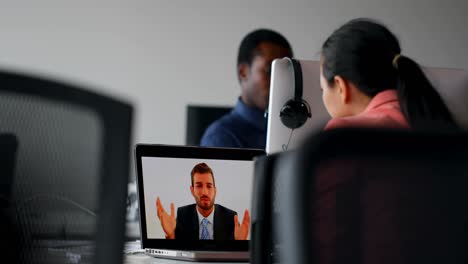 mujer de negocios haciendo una llamada de video en una computadora portátil en la oficina 4k