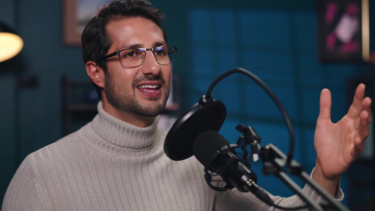 Giovane uomo che parla al microfono in uno studio casalingo.
