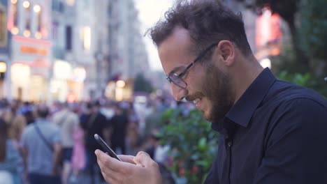 Un-Joven-Riendo-Enviando-Mensajes-De-Texto-Por-Teléfono.