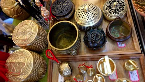 a display of chinese tourist souvenirs including brass pots and kettles