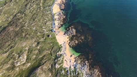 Top-down-Shot-Of-Turquoise-Blue-Sea-And-Rocky-Coast-At-The-Coral-Strand-Beach-In-Connemara,-Ireland---aerial