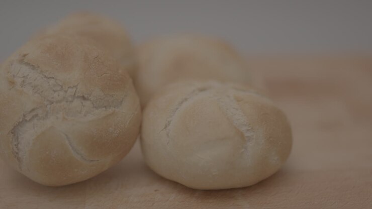 Slow motion pan of kaiser roll on a wooden plank