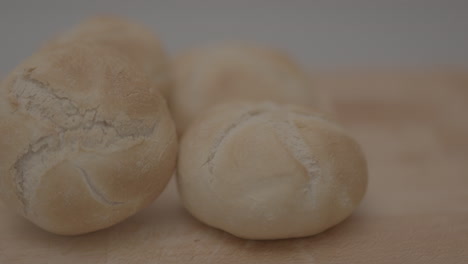 Slow-motion-pan-of-kaiser-roll-on-a-wooden-plank