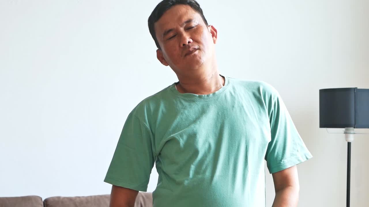 Mature asian Man stretching indoors enjoying leisure time at home