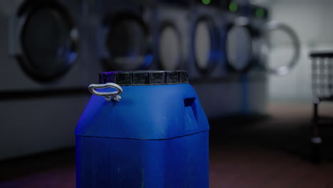 blue container of laundry detergent in a laundry mat