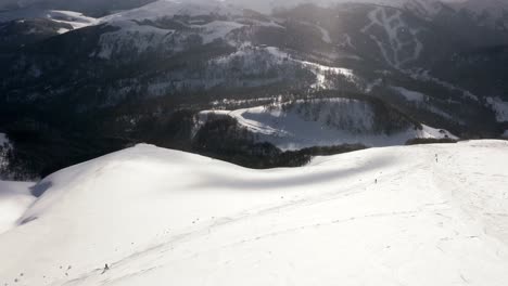 aerial - people skiing in the mountains at kolasin ski resort, montenegro, pan right