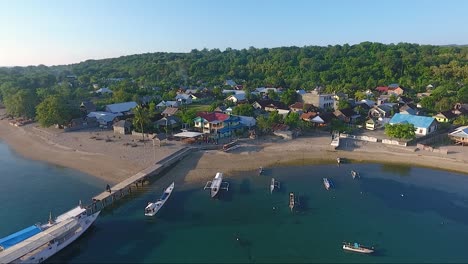 barcos tradicionais por cais na idílica vila costeira na ilha de moyo, indonésia