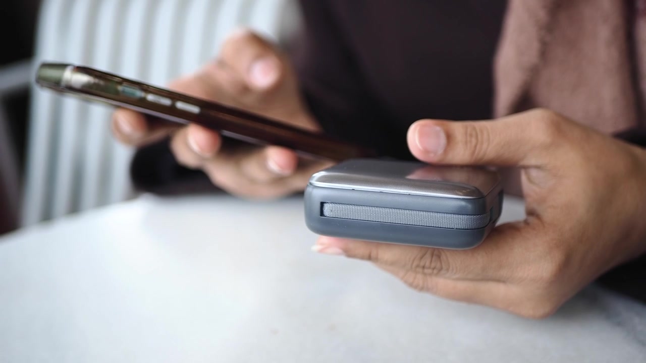 Persona con smartphone e power bank portatile