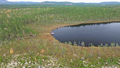 Still-Water-Of-A-Lake-Surrounded-By-Autumnal-Fir-Forest-Trees-In-Sweden