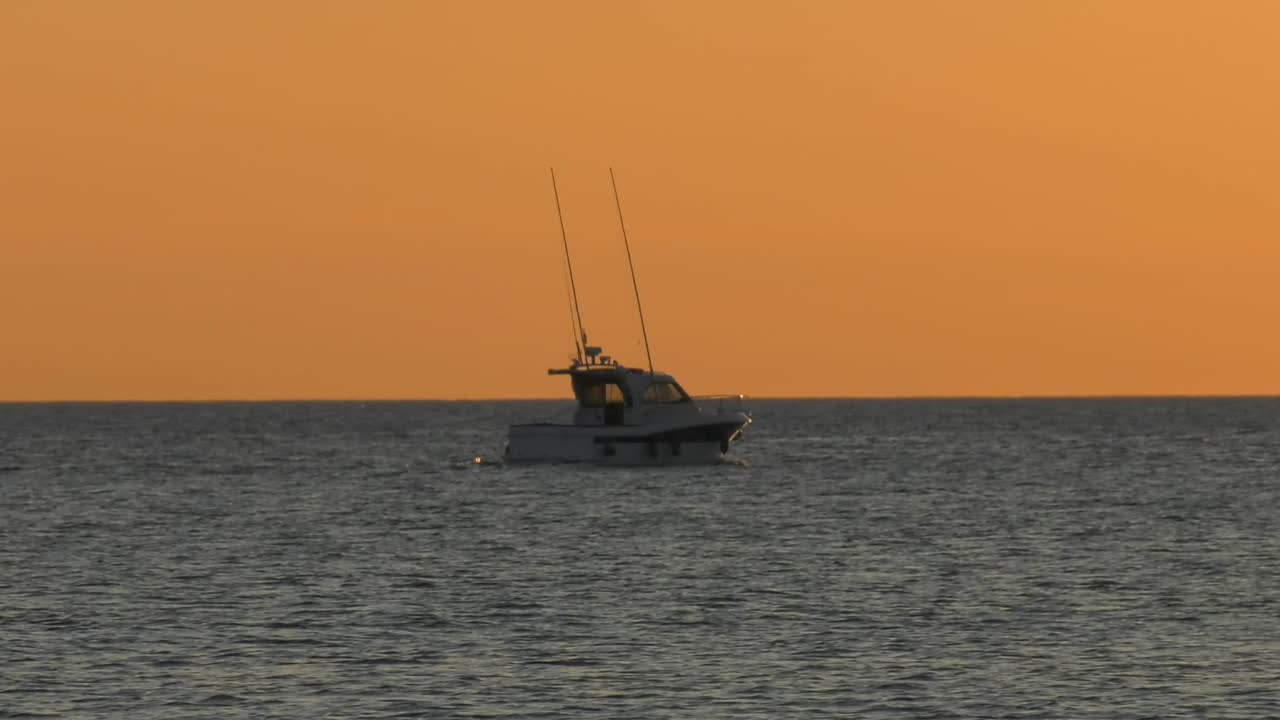 Sport fishing boat cruising at dawn on silver sea, Spain