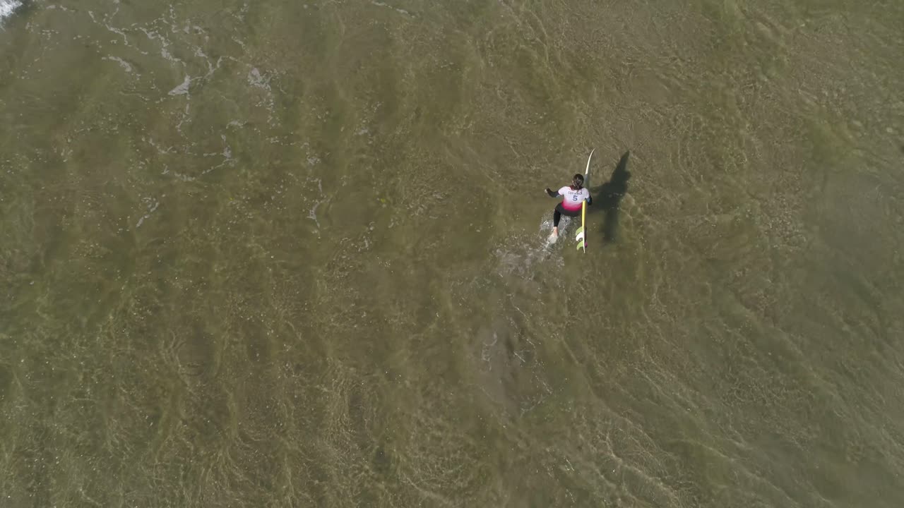 surfista caminando por el agua toma aérea
