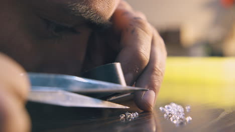 el joyero mira las gemas brillantes en la mesa de madera de cerca