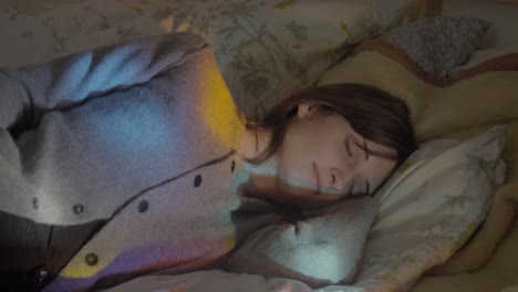 Girl-sleeping-bed-with-disco-lights-medium-shot