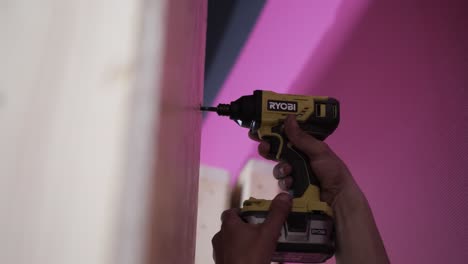 close-up of a drill driver being used to insert a screw into a wooden surface