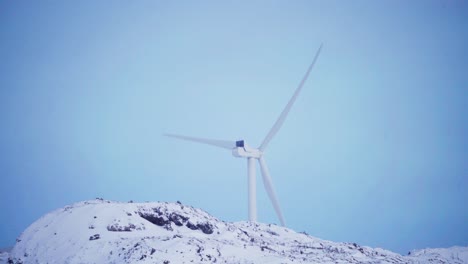 Wind-Turbine-Propeller-On-Snow-Mountains-Against-Blue-Sky