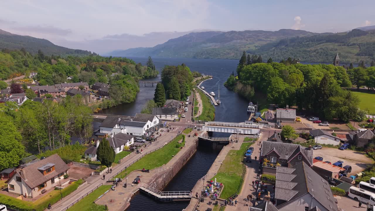 Drone footage revealing the Caledonian Canal as it runs through Fort Augustus, with the legendary Loch Ness and surrounding Highlands unfolding in the background
