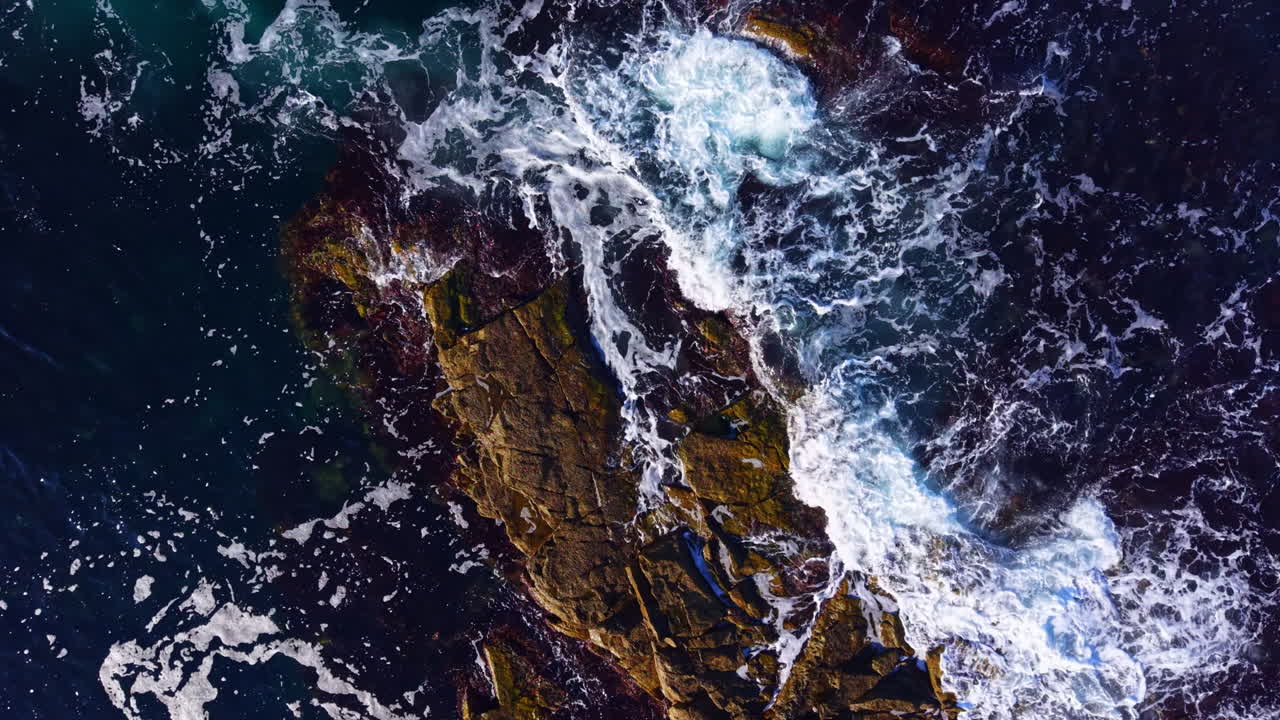 Waves crashing on rugged rocks create a stunning dance of nature along the coast at sunset