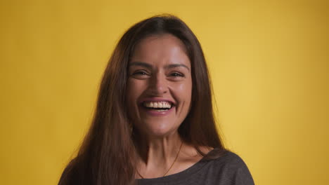 retrato de estudio de una mujer emocionada celebrando buenas noticias ganando dinero contra un fondo amarillo 1