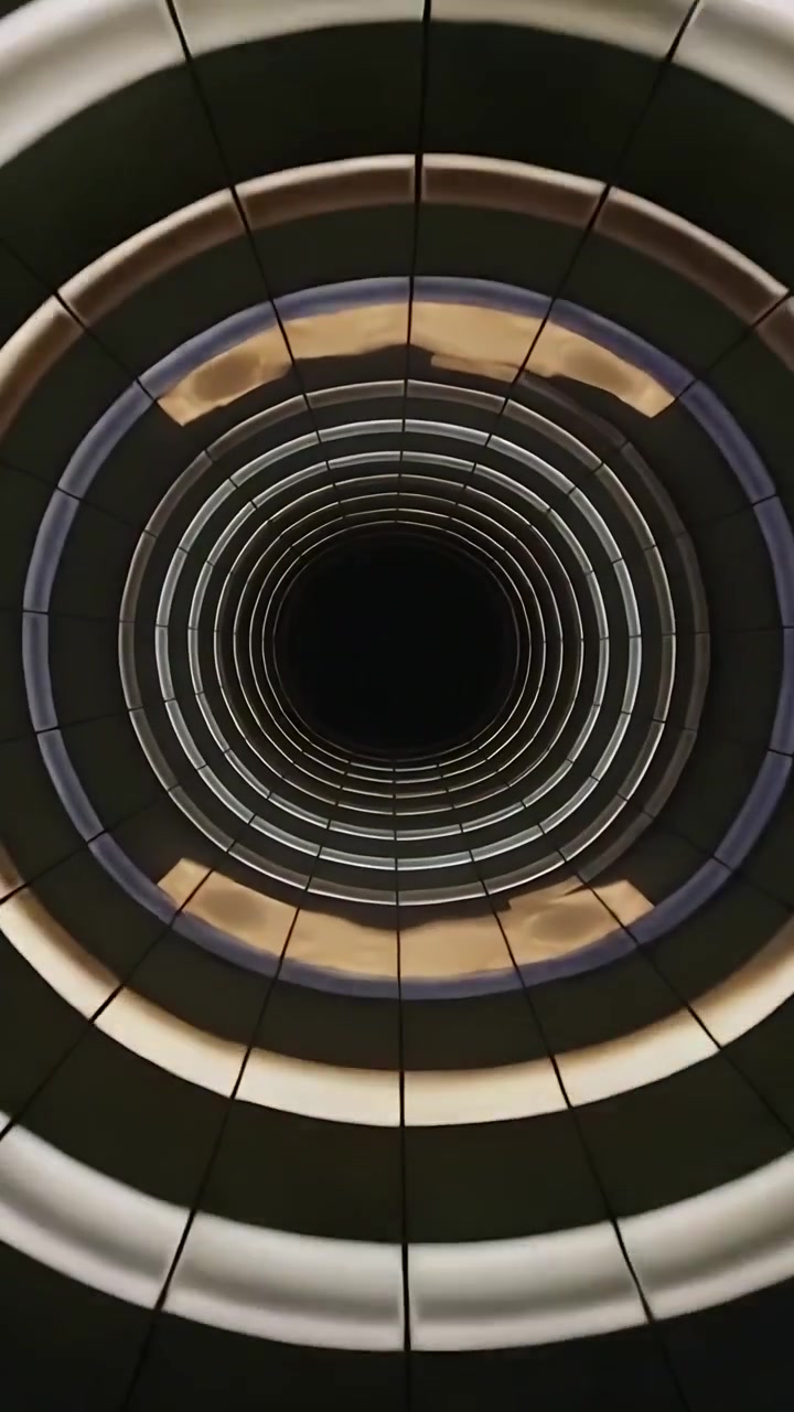 Video verticale: Anelli di avvio del programma che ruotano verso l'interno, cambiando colore in un atrio; giunture, nucleo scuro.