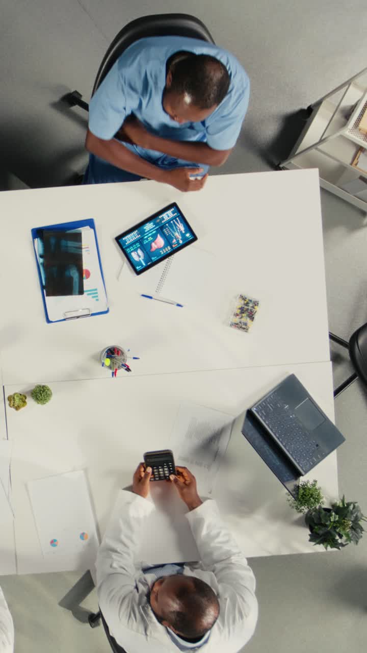 Top-down vertikal video, hvor kirurger og personale på en klinik zoomer ind og diskuterer behandlingsmuligheder