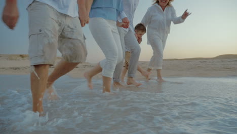 family walking on the beach and splashing water