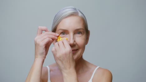 woman applying gold eye patches