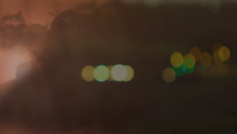 transmission tower with bokeh lights and lightning in clouds