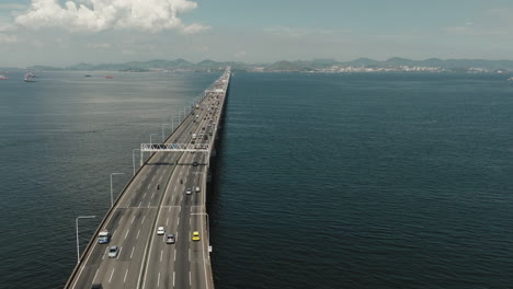 El-Puente-De-La-Carretera-Con-Vista-Circular-Aérea-Sobre-El-Océano-Conduce-A-La-Ciudad-De-Río-De-Janeiro,-Brasil.