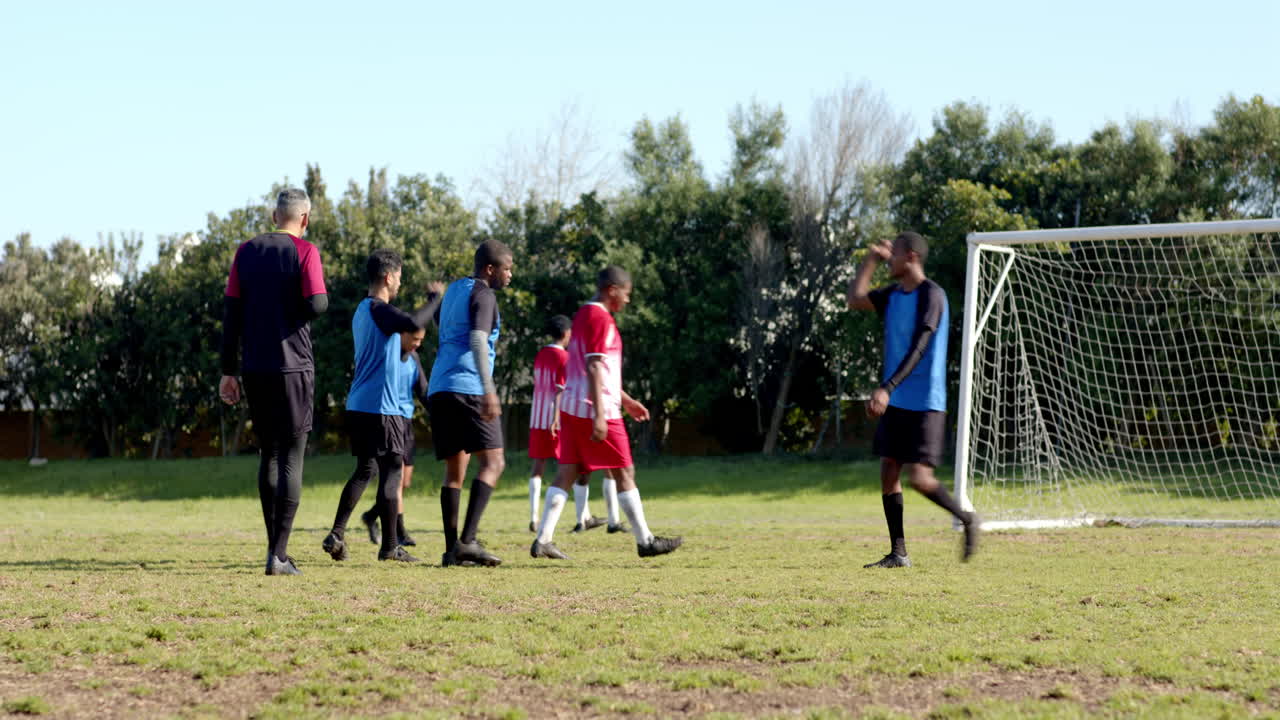 Playing soccer on field, teams in blue and red jerseys competing actively
