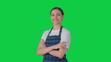 retrato de una feliz ama de casa india de pie con las manos cruzadas pantalla verde