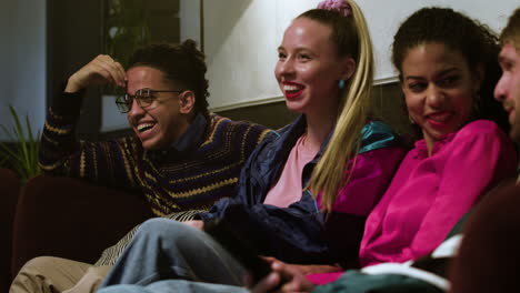 friends watching tv on the sofa