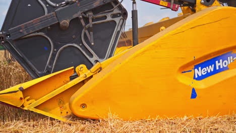 combines in the field. an agricultural machine collects wheat grain over a large field