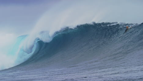 thick heavy ocean wave from cloudbreak fiji crashes with whitewash spraying into air, slow motion