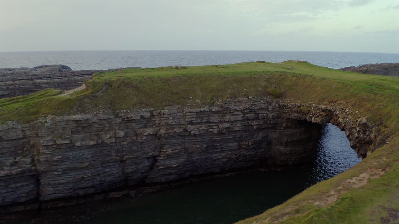 Aerial trucking shot glides over the edges of Bridges of Ross, revealing its structure.