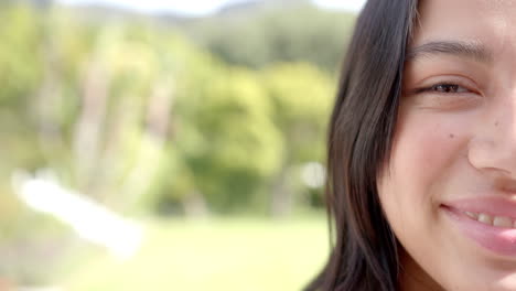 Half-portrait-of-happy-biracial-teenage-girl-smiling-in-sunny-garden,-copy-space,-slow-motion