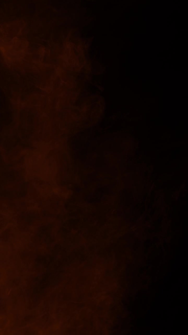 Effetto fumo e nebbia arancione che si muove lentamente. Isolato su sfondo nero, ideale per il compositing, formato verticale.