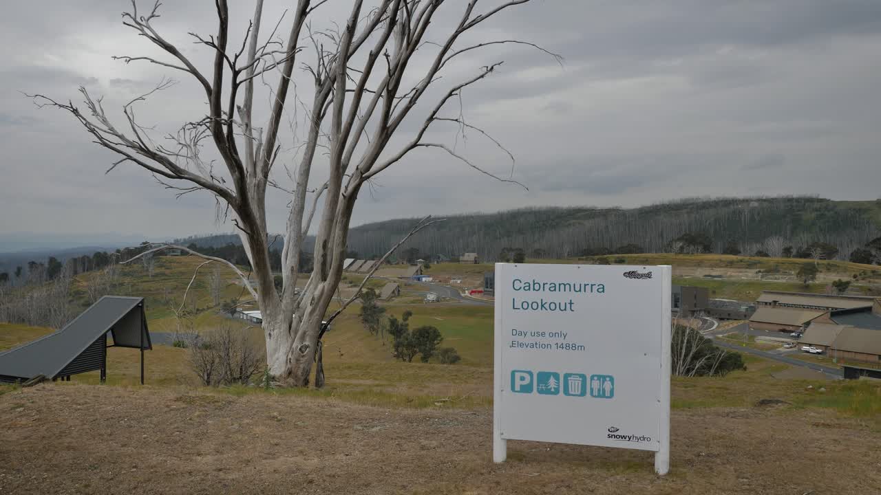 View from Cabramurra lookout including signage and town, in the Snowy Mountains region of New South Wales.