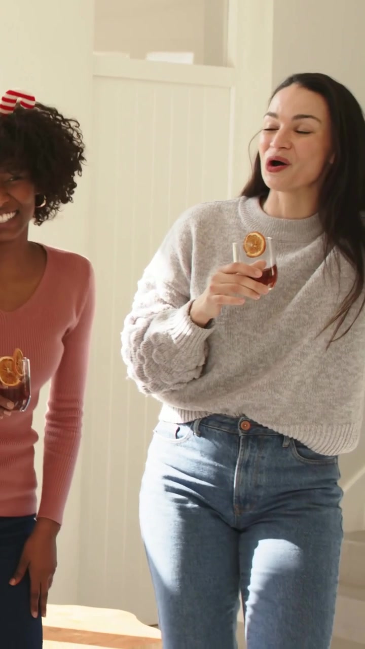 Video verticale: Due donne che ridono, cantano e ondeggiano dopo la chiamata di un'amica, a casa con gli occhiali.