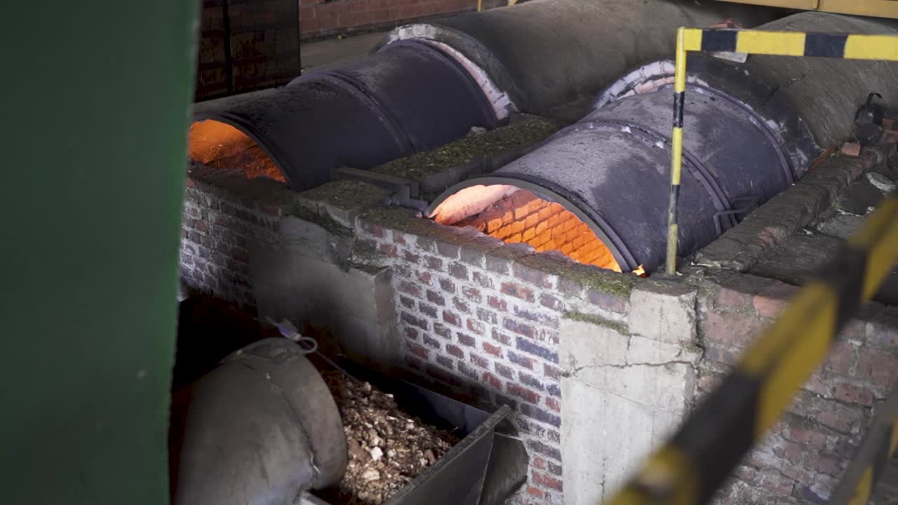 An industrial shot of large, wood-fired rotary drum dryers used in the traditional "secado" process of drying yerba mate leaves in Misiones, Argentina