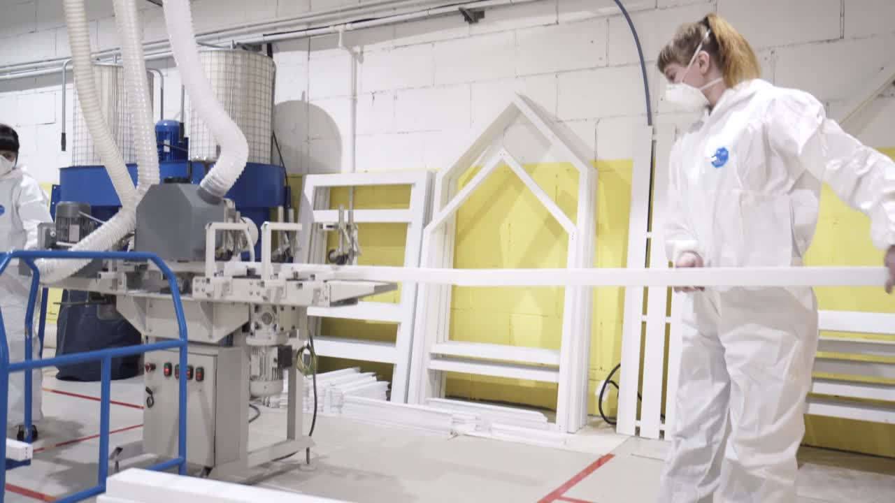mujer trabajando en una fábrica montando marcos de ventanas