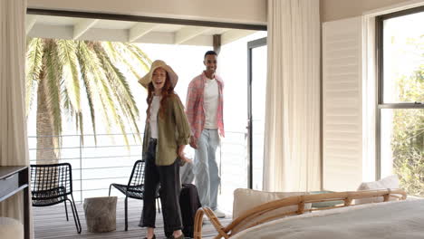 happy couple arriving at vacation home with luggage, enjoying holiday getaway