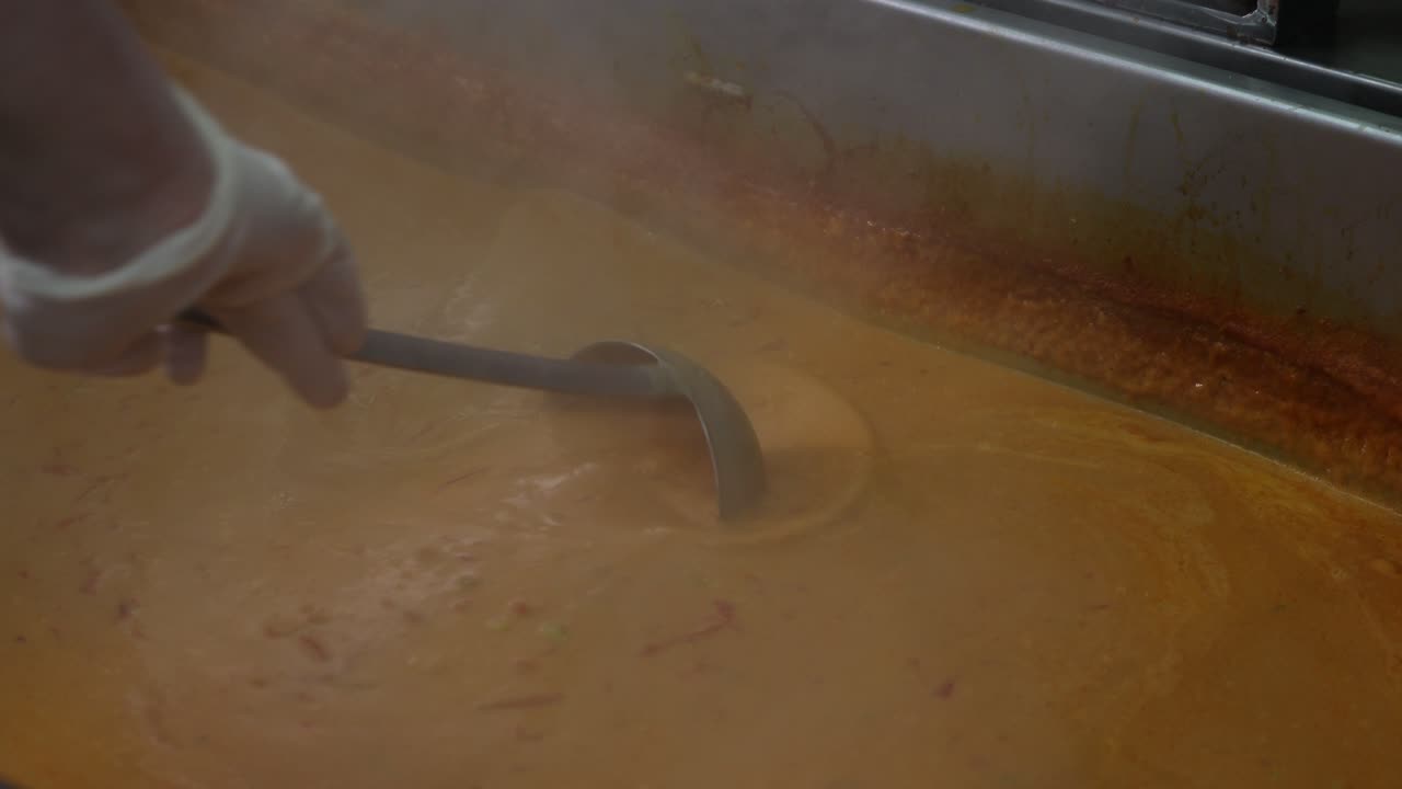 Chef mixing curry sauce, close up on a hand, 4k footage-1