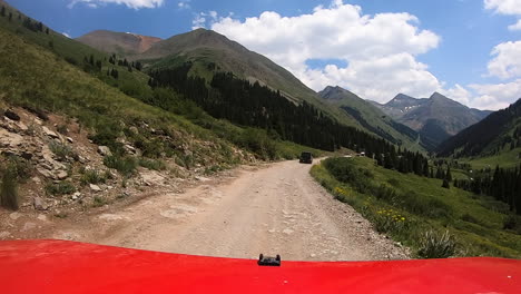 punto de vista sobre el capó de un vehículo 4wd que atraviesa un amplio sendero a través del valle del río animas en las montañas de san juan de colorado