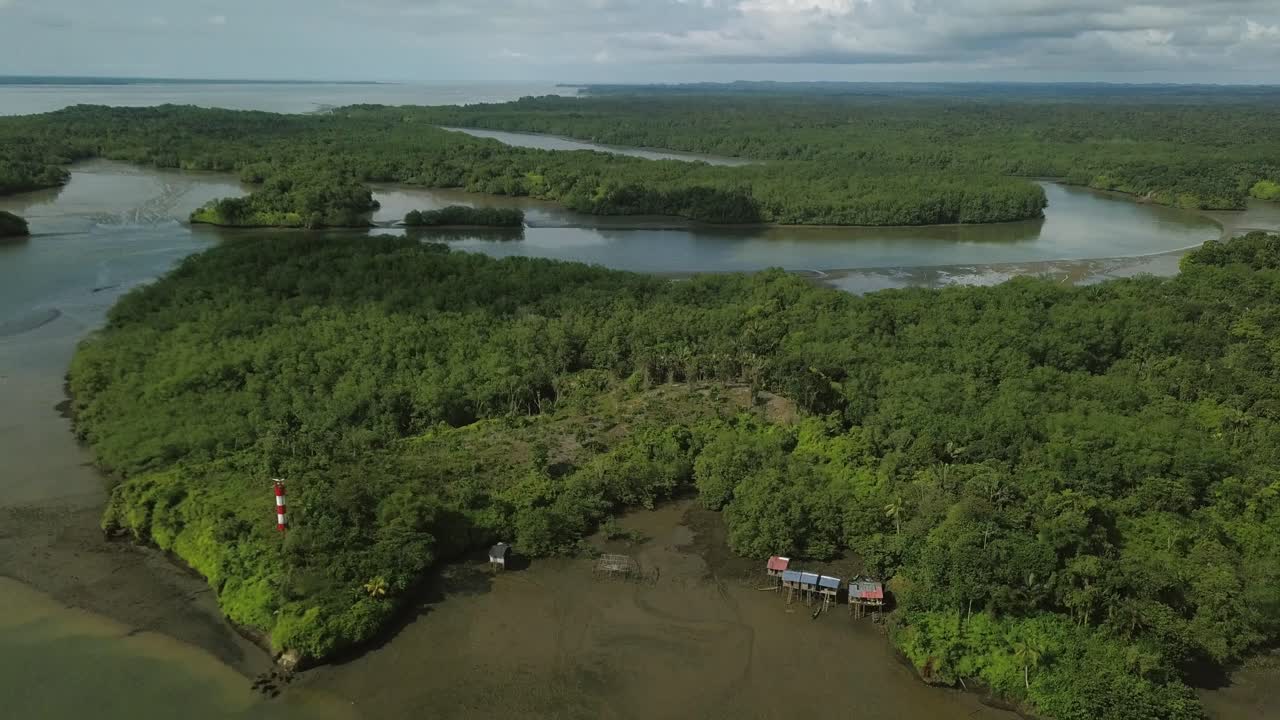 Aerial flyover estuaries lighthouse and fishermen stilt houses in Colombia